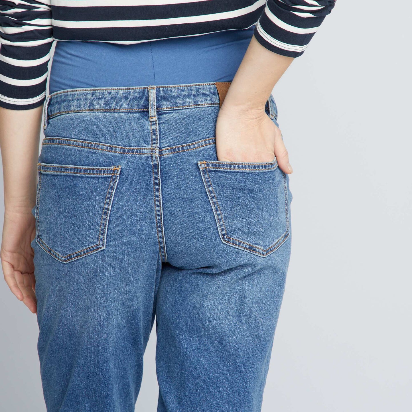 جينز بقصة الأم مع تفاصيل ممزقة باللون الأزرق