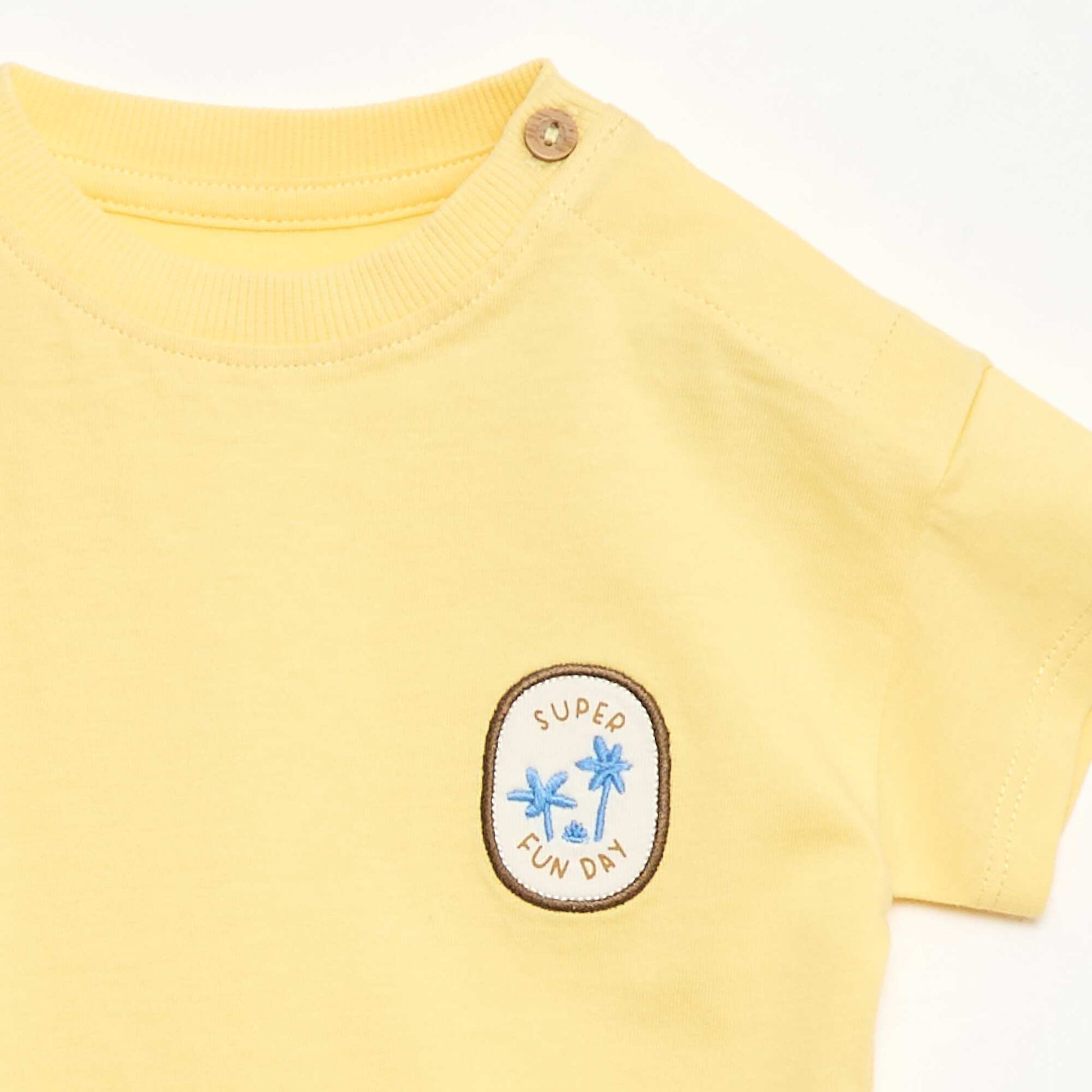 تي شيرت مزين بتطريز على الصدر باللون الأصفر